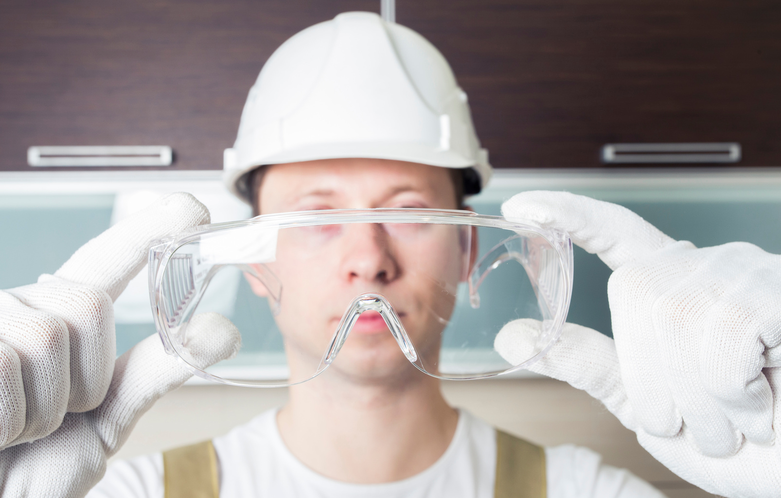 Worker holding transparent safety glasses